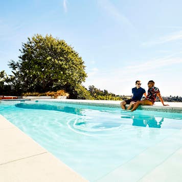 couple sitting by a pool at a vacation rental