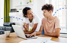 mother and teenage son talking and looking at computer