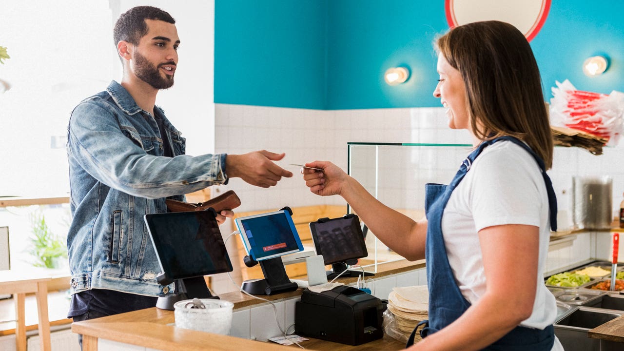 man paying with credit card at cafe counter