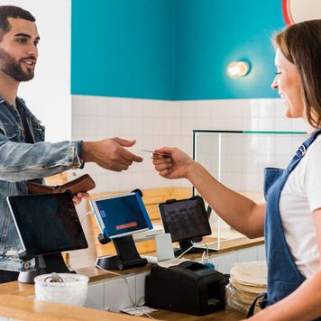 man paying with credit card at cafe counter