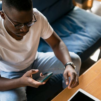 man sitting on couch and looking at his phone