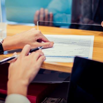 close up of bank teller's hands giving paperwork to a customer