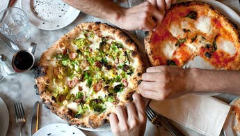 Hands Reach for Naples-Style Pizza at a restaurant