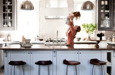 Mother lifting daughter in kitchen
