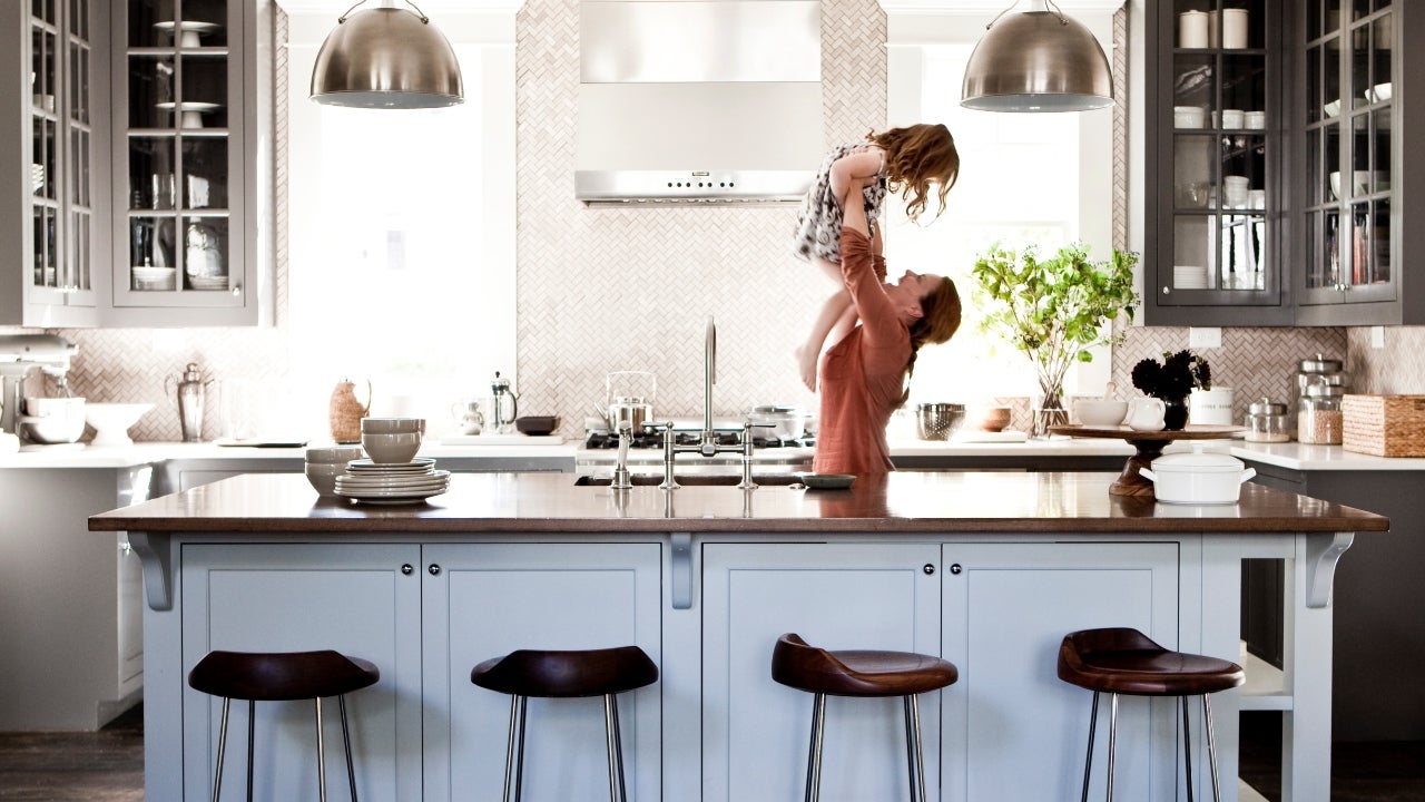 Mother lifting daughter in kitchen
