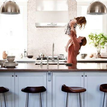 Mother lifting daughter in kitchen