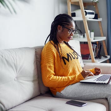 woman on couch using laptop computer
