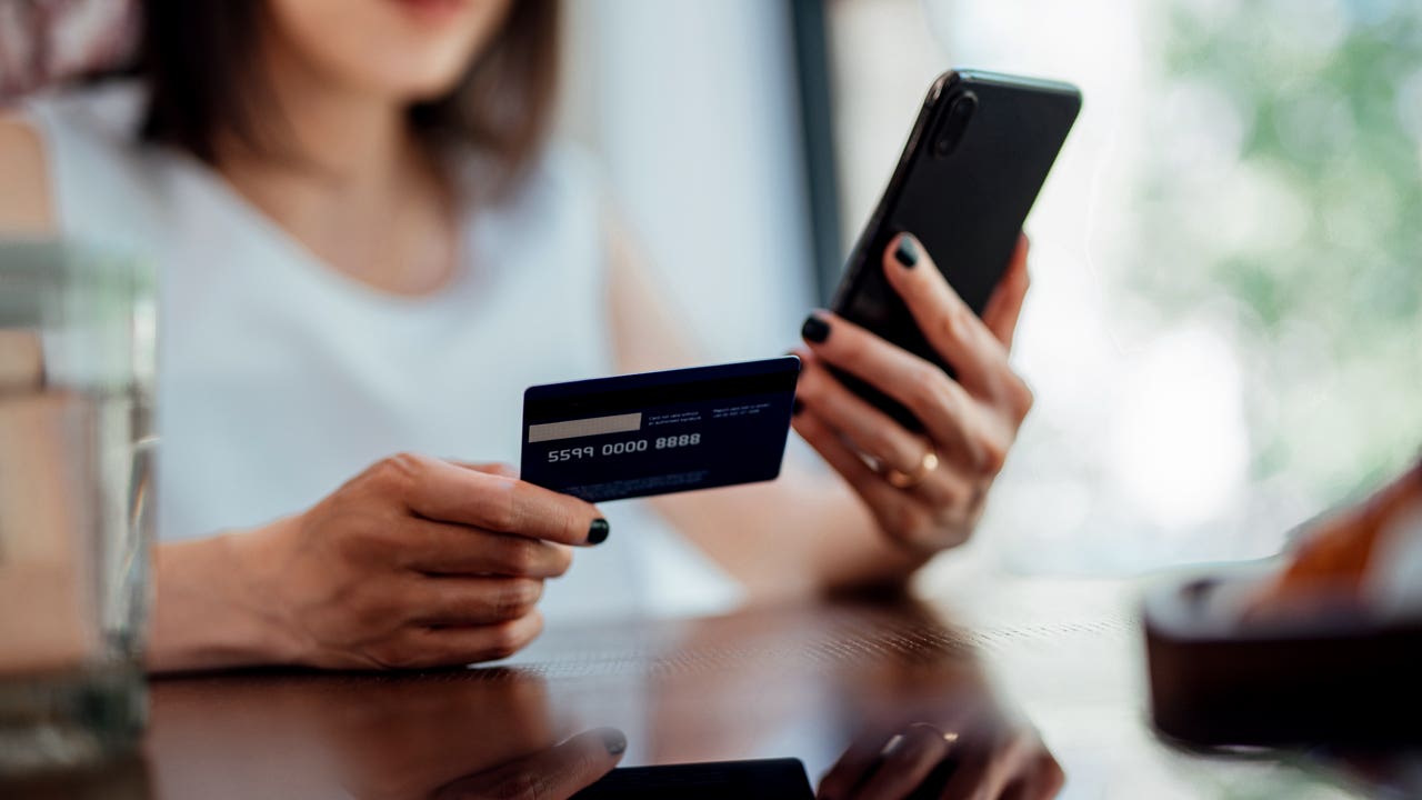 close up of hands holding credit card and phone