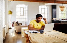 man sitting at home working on laptop computer