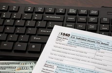 Income tax return and computer keyboard. Online filing, tax software and e-file