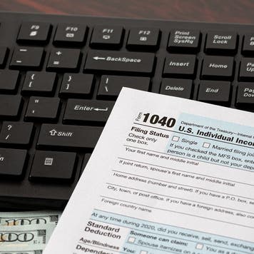 Income tax return and computer keyboard. Online filing, tax software and e-file