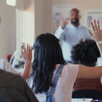 High school teacher calls on students in classroom