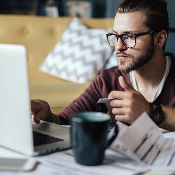 man paying bills online with a credit card