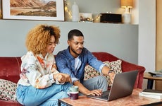 Man and woman talking while using laptop