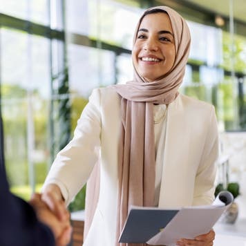 Woman shakes a hand during a job interview