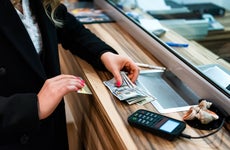 close up of woman handing cash at bank counter