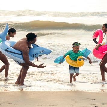 family playing together in the ocean waves on the beach