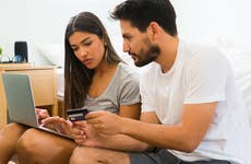 couple paying bills on a laptop at home