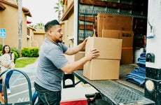 Father loading boxes into moving truck during family move