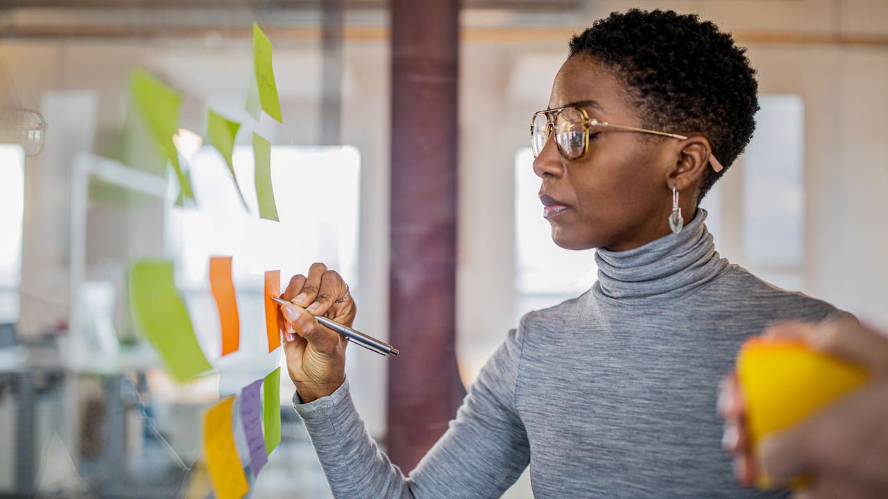 businesswoman writing ideas on sticky notes