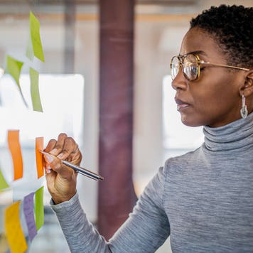 businesswoman writing ideas on sticky notes