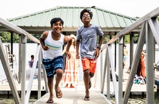 Children running down the dock at a lake house