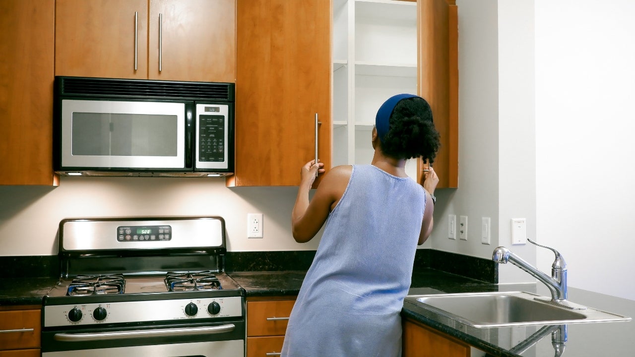 Women opens cabinet doors while touring condo