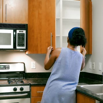 Women opens cabinet doors while touring condo