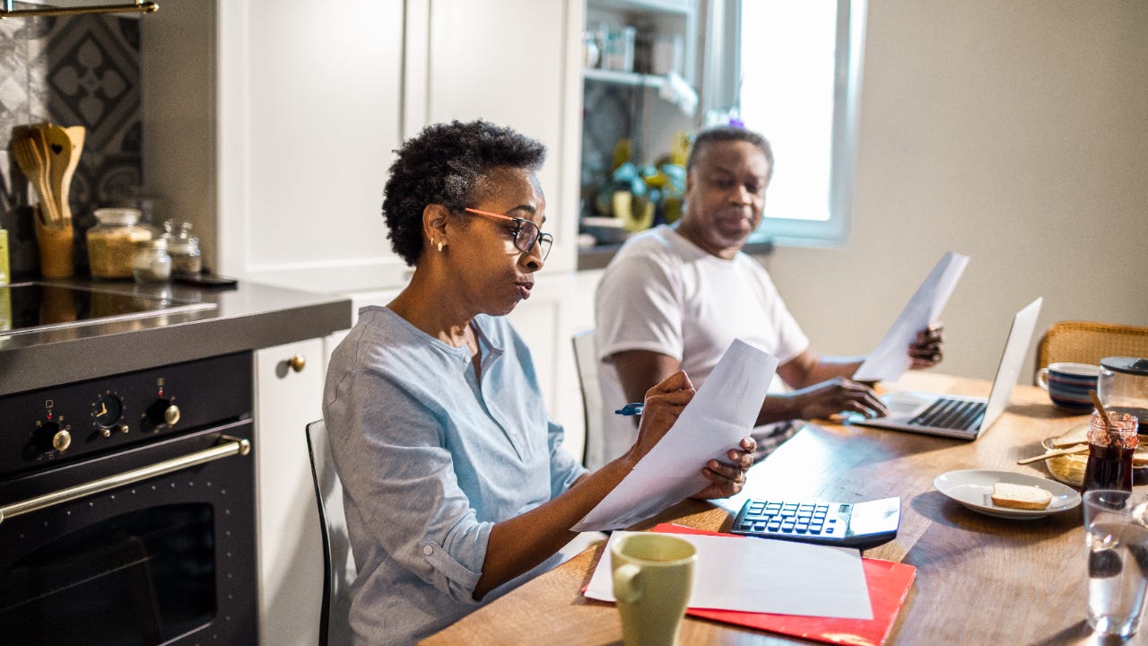 A couple works on taxes at their kitchen table