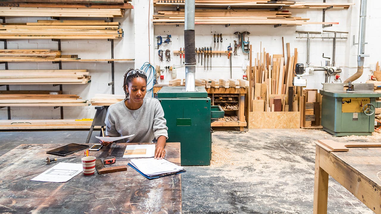 Young black female designer working in a woodworking workshop