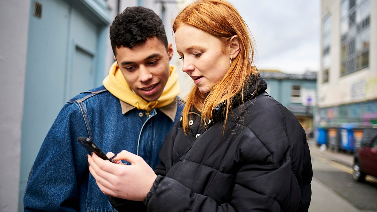 two teenage friends looking at a smartphone