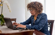 woman sitting at table and working on laptop computer