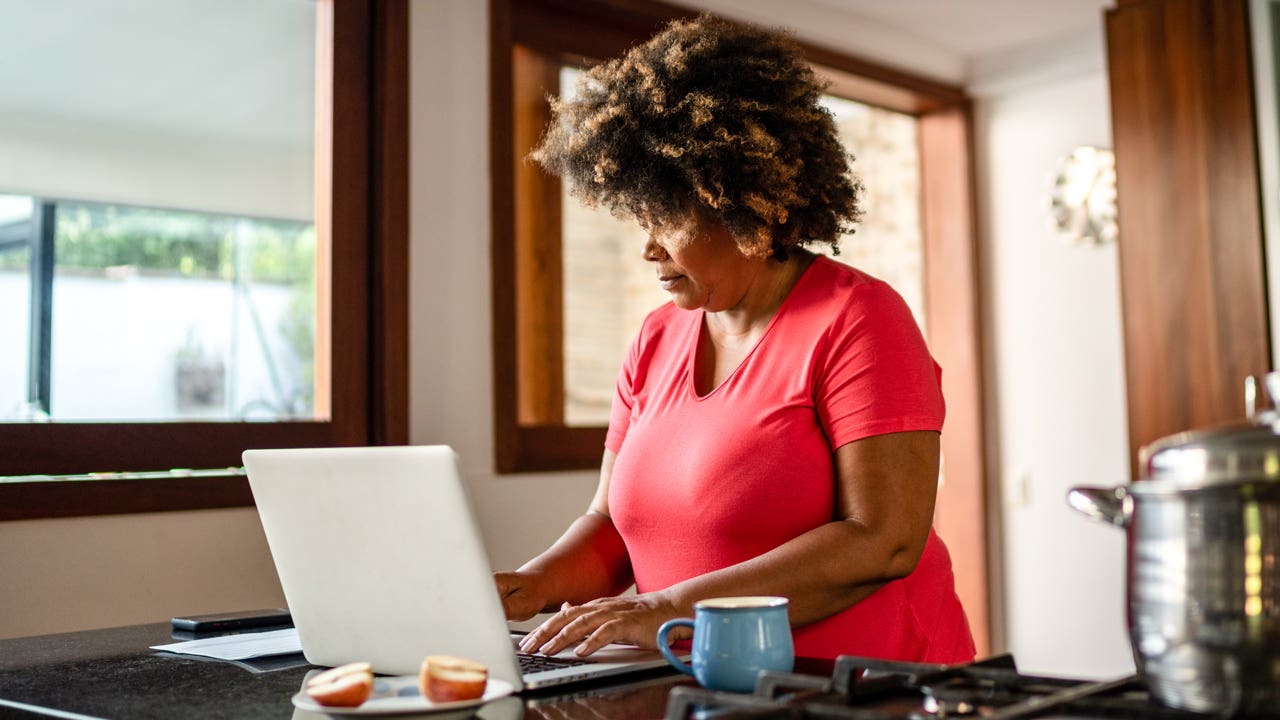 woman working on her laptop in the kitchen