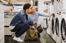 sales person talking to customer about a washing machine in a store