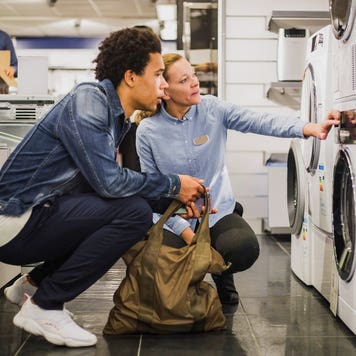 sales person talking to customer about a washing machine in a store