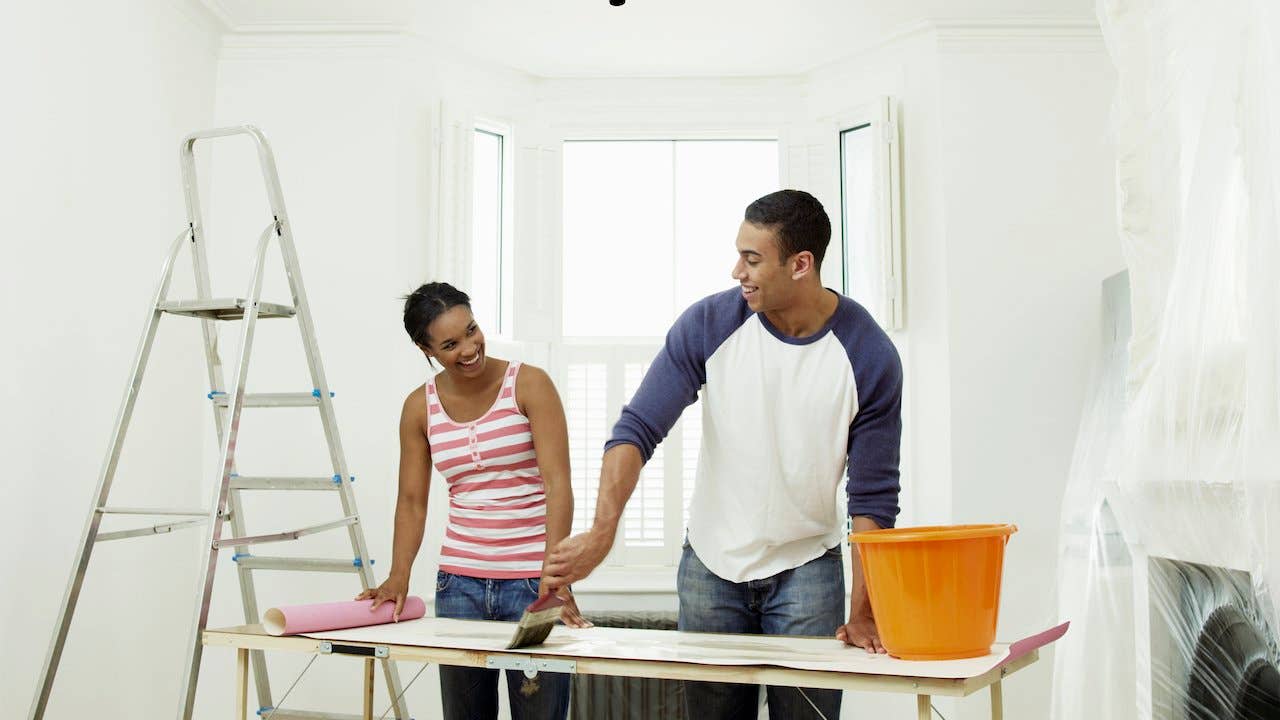 Two people working together to complete a painting project