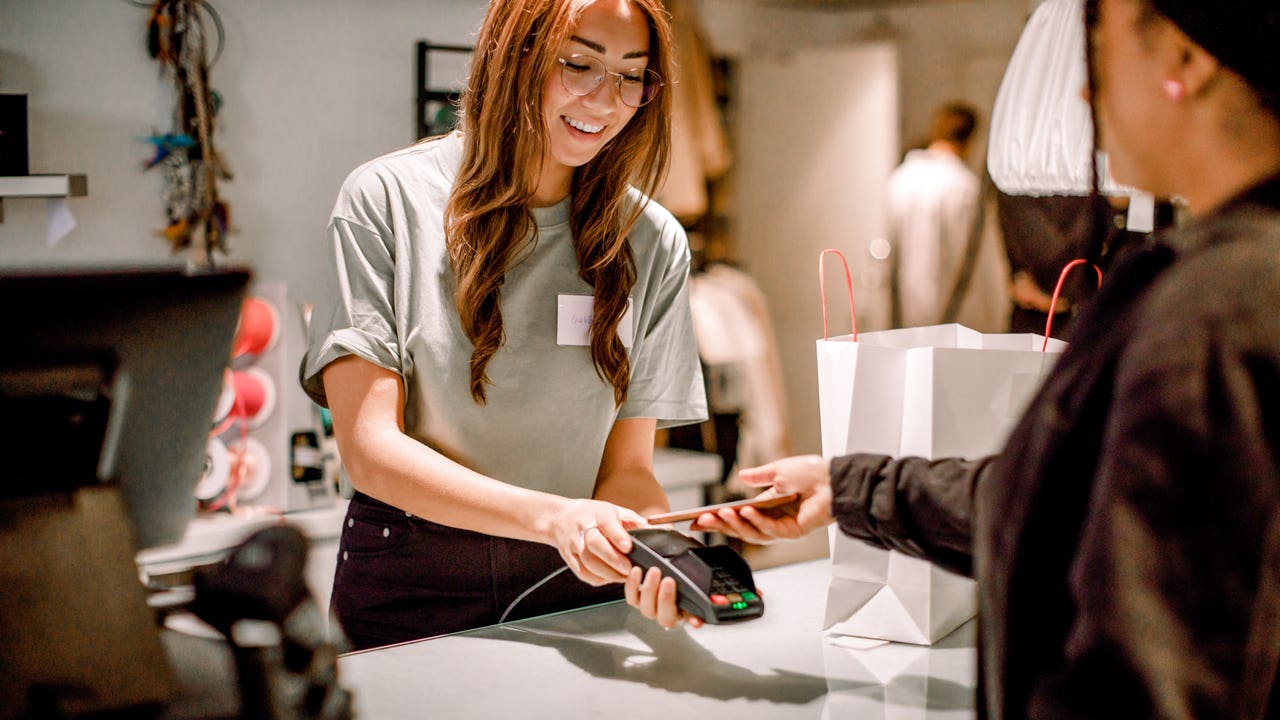 customer in a store paying for a purchase with her phone