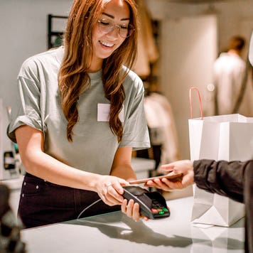 customer in a store paying for a purchase with her phone