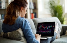 Woman researches stocks on laptop