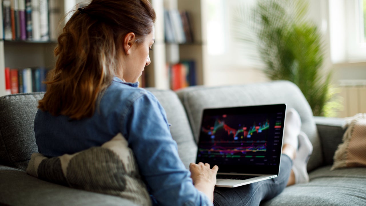 Woman researches stocks on laptop