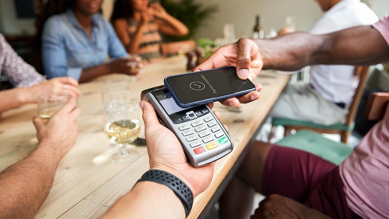 person paying for a bill at a restaurant with contactless phone app