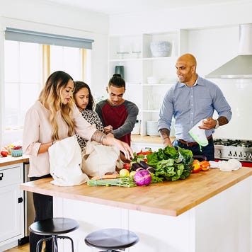 family unpacking groceries in the kitchen