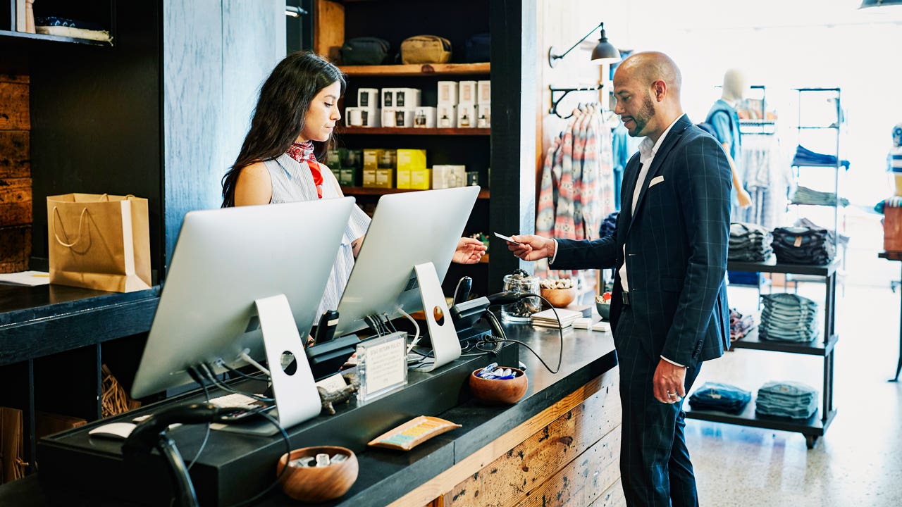 man paying with a credit card in a clothing store