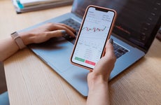 Woman looks at stock chart on her phone