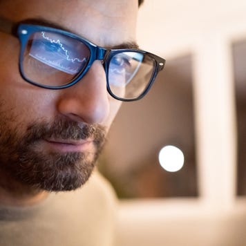 A man with glasses reflecting his trading screen
