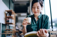 Woman reads a book in a cafe