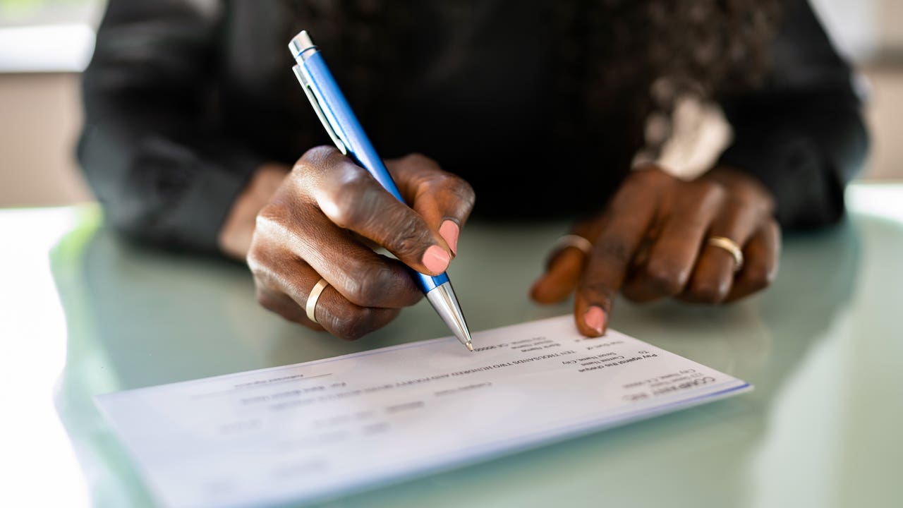 close up of hands writing a check