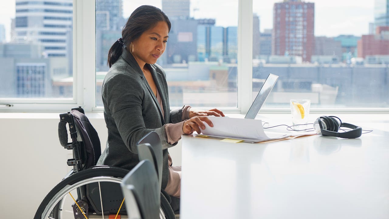 businesswoman who uses a wheelchair working in an office