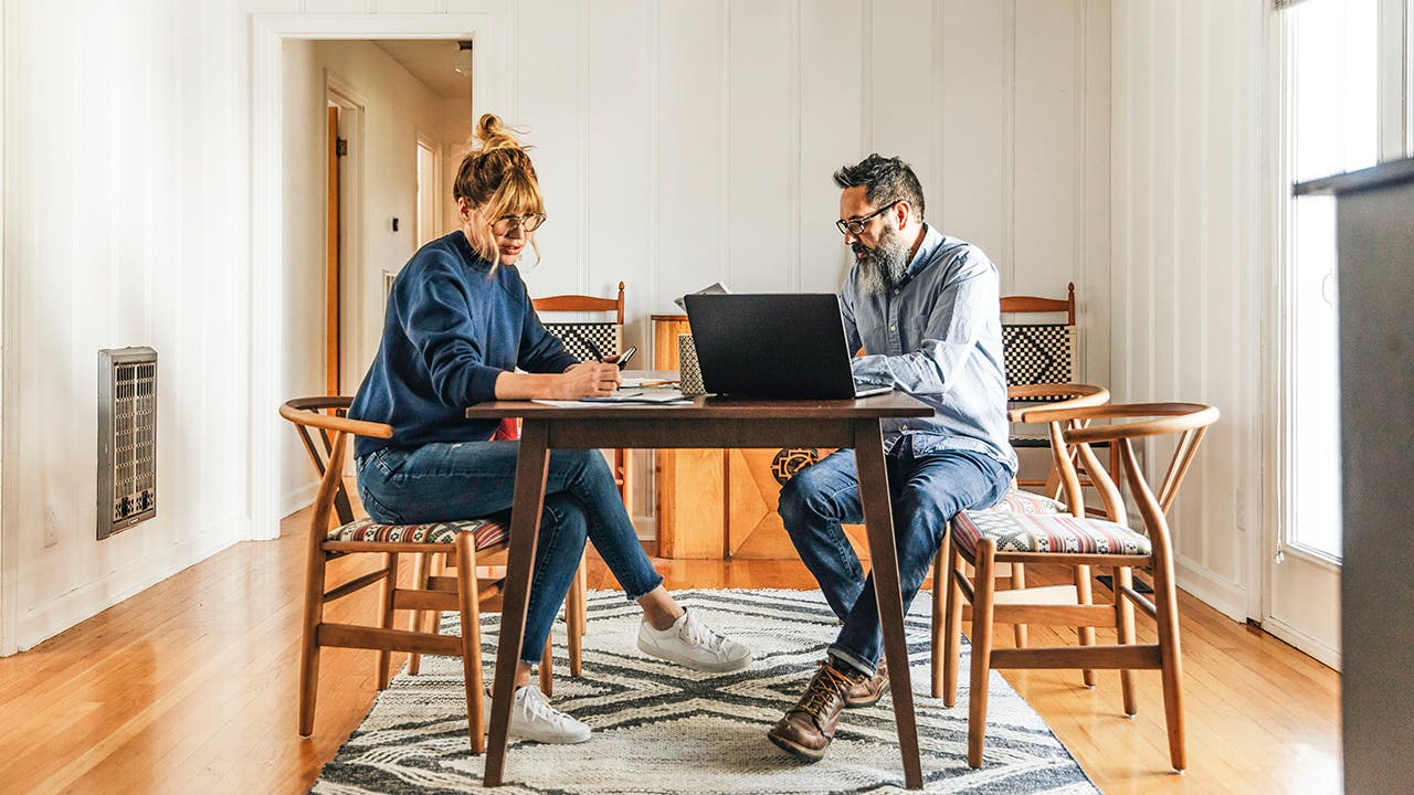 Side view of couple paying bills