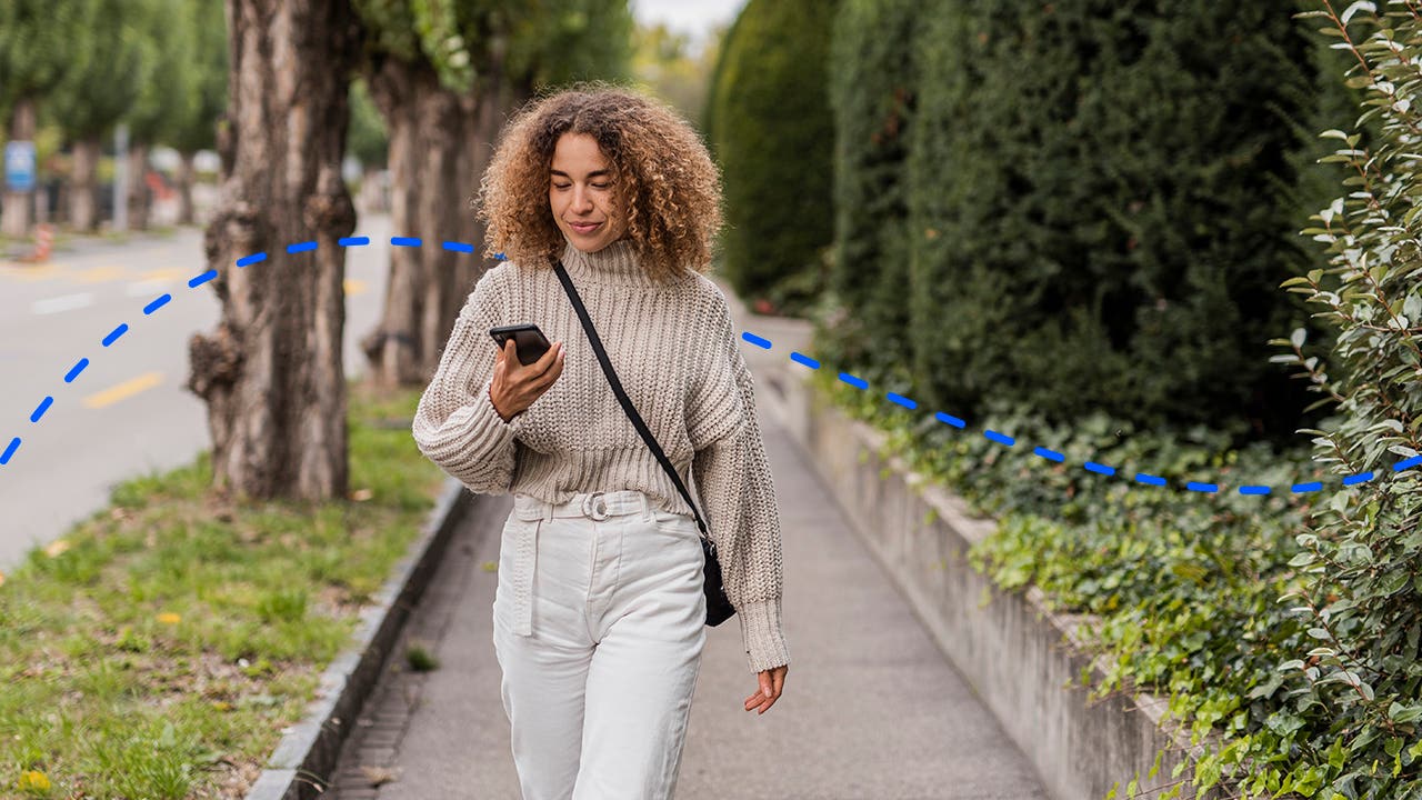 woman looking at her phone while on a walk